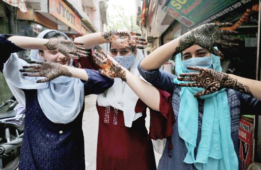 Girls show their hands applied with henna on the eve of Eid-al-Fitr festival, in Jammu on Monday. 