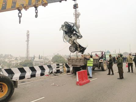 A crane lifts the wrecked car after it met with an accident, at Sidhra Flyover, in Jammu on Friday. One person reportedly killed in the accident. ANI Photo