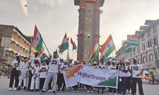 Participants hold the tri color as they take part in Har Ghar Tiranga rally from Kashmir to New Delhi during the celebration of abrogation of article 35A and 370 on its 3rd anniversary, at Ghanta Ghar Lal Chowk, in Srinagar on Friday. ANI Photo
