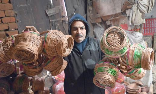 A vendor sells traditional fire pots (Kangris) in Jammu on Saturday.