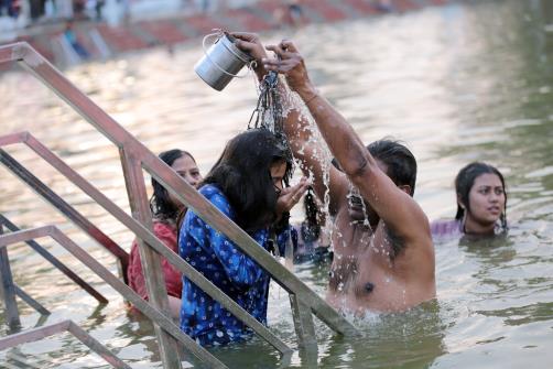 Devotees take dip in a pond during Jhiri Mela, at Shama Chak Jhiri near Jammu on Tuesday.