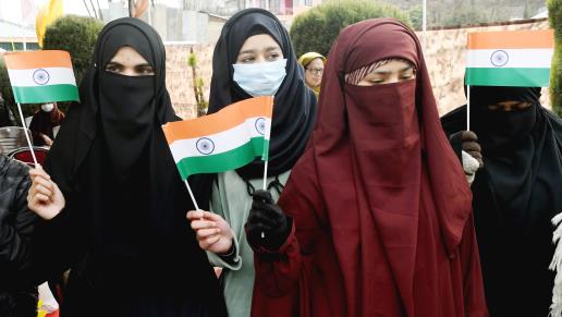 Students holds National flag during the establishment of the National flag post in the Government Boys Senior Secondary School, Humhama, under operation Sadbhavna, in Budgam on Wednesday.