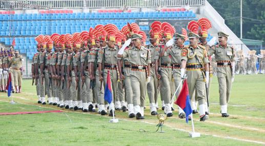 Police personnel march past during the full dress rehearsal for the 77th Independence Day, at MA Stadium in Jammu on Sunday.