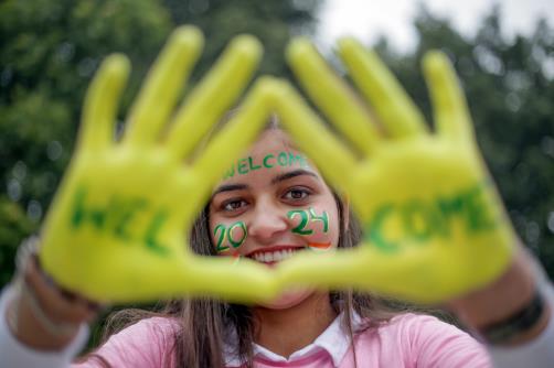 A girl poses with her face and hands painted with slogans as she welcomes the new year 2024, in Amritsar on Sunday. 